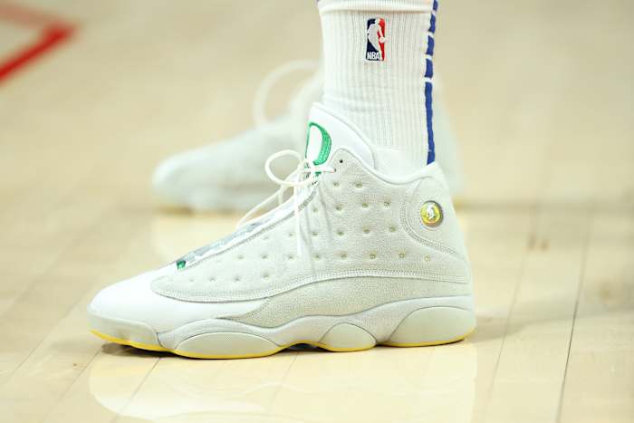 View of white and green Air Jordan shoes.